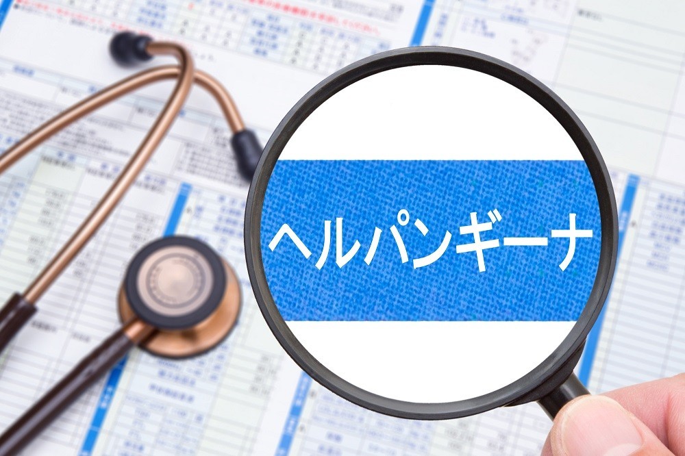 虫眼鏡で拡大された「ヘルパンギーナ」の文字