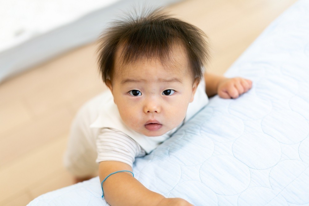 つかまり立ちをしている赤ちゃん