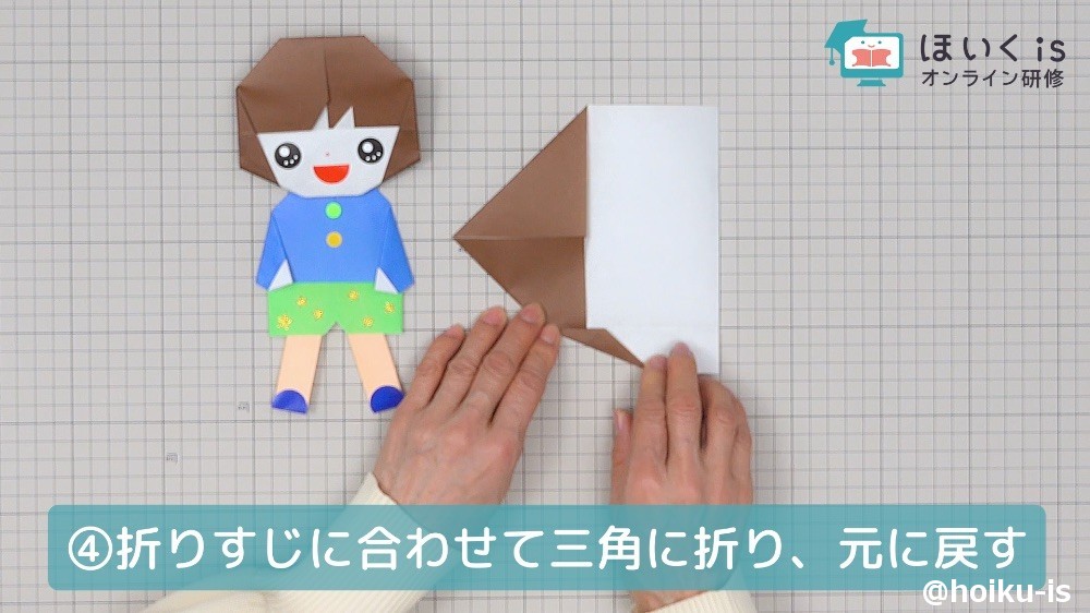 折りすじにあわせて折り紙を三角に折る