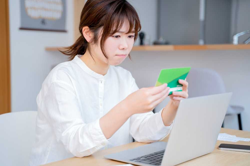 通帳を見て悩む保育士