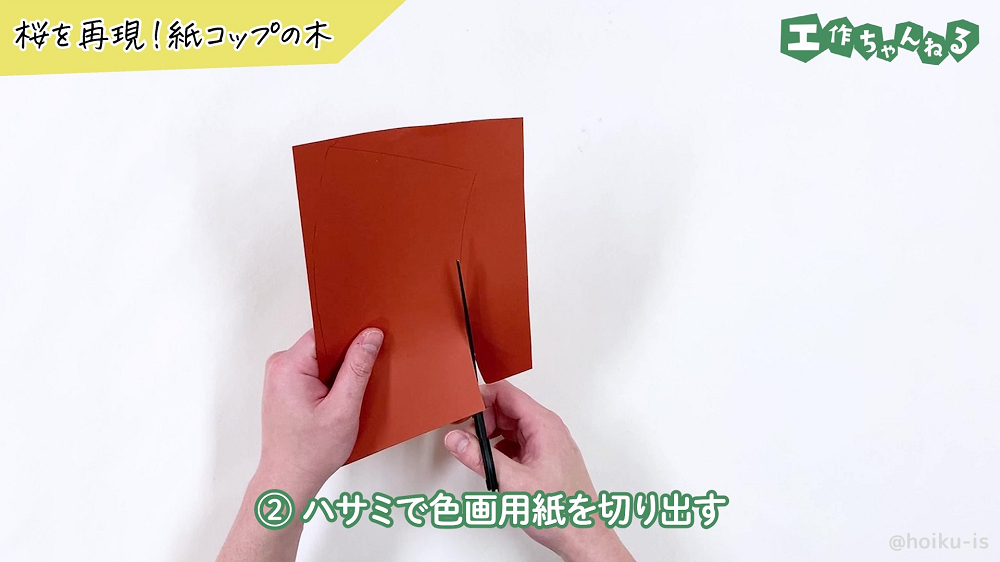 型取りした線に沿って画用紙を切っている様子