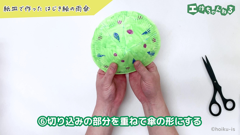 切れ込みに沿って紙皿を重ねている手元