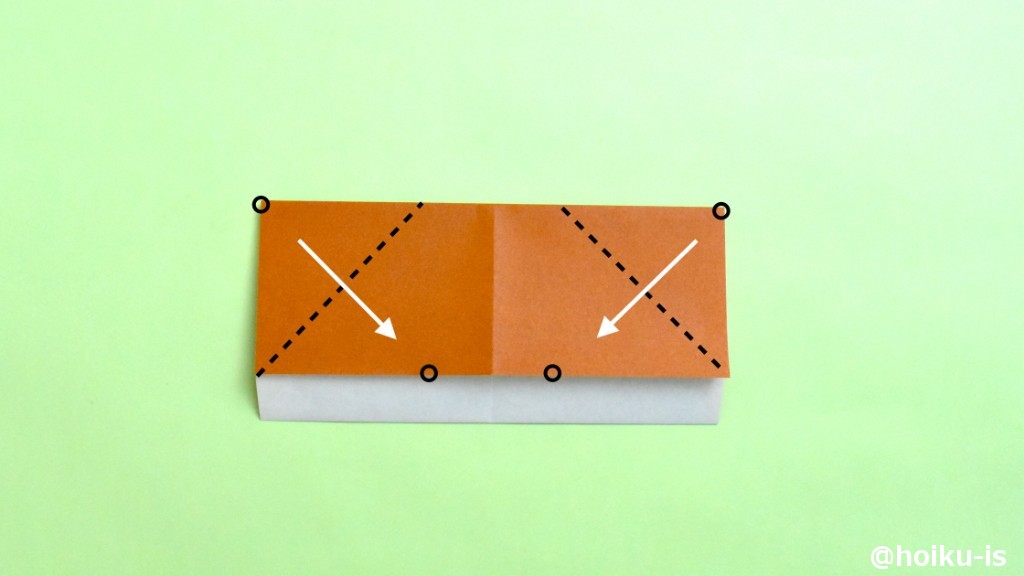 左右の角（○印）を、下の辺にある○印に合わせるように角を谷折りにします。