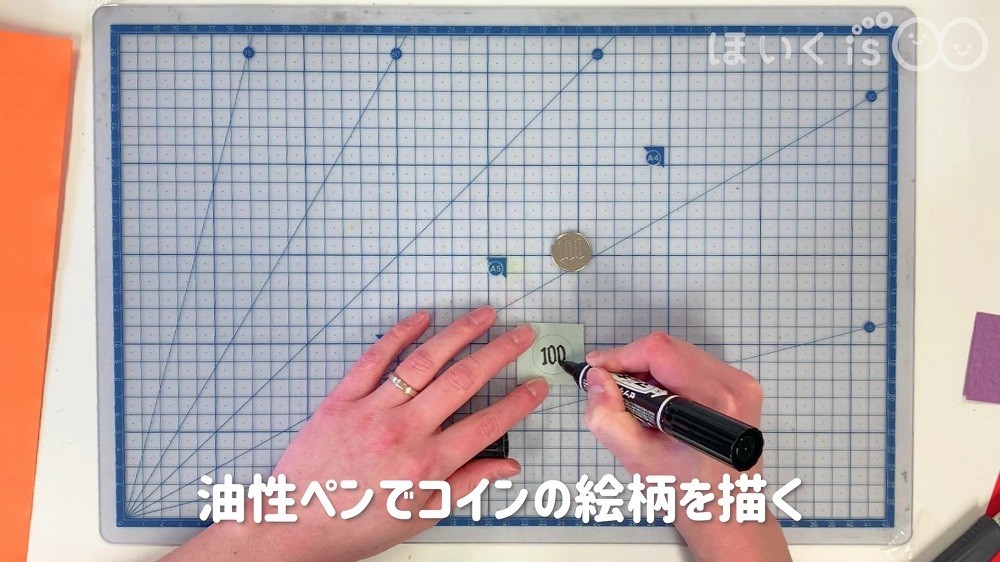 油性ペンでコインの絵柄を描きます