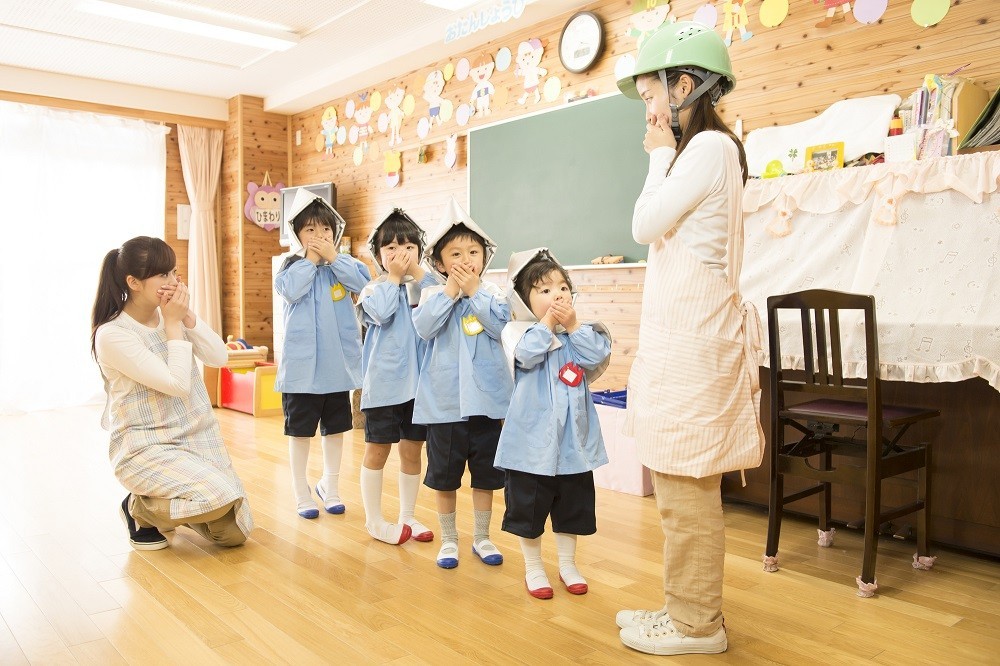 火災発生時の訓練をする子どもと保育士