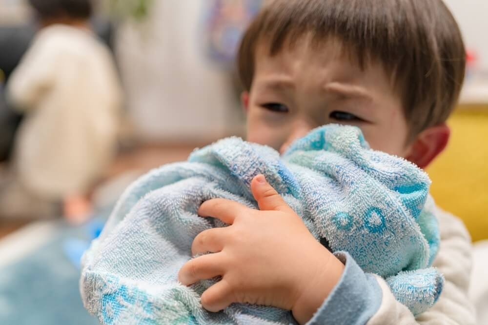 タオルを抱きしめる男の子の画像
