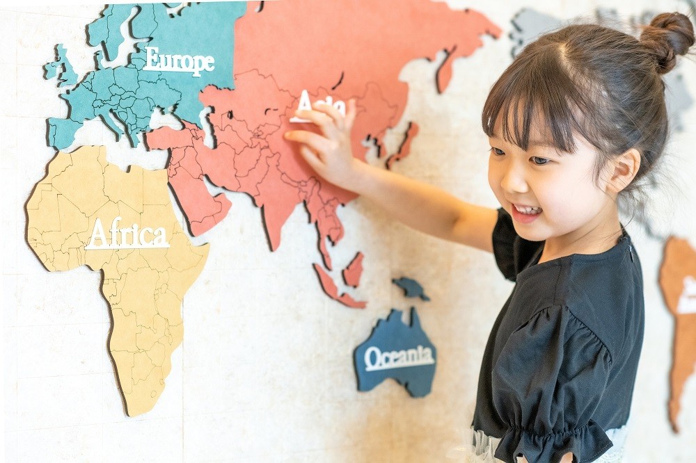 世界地図を指し示す女の子
