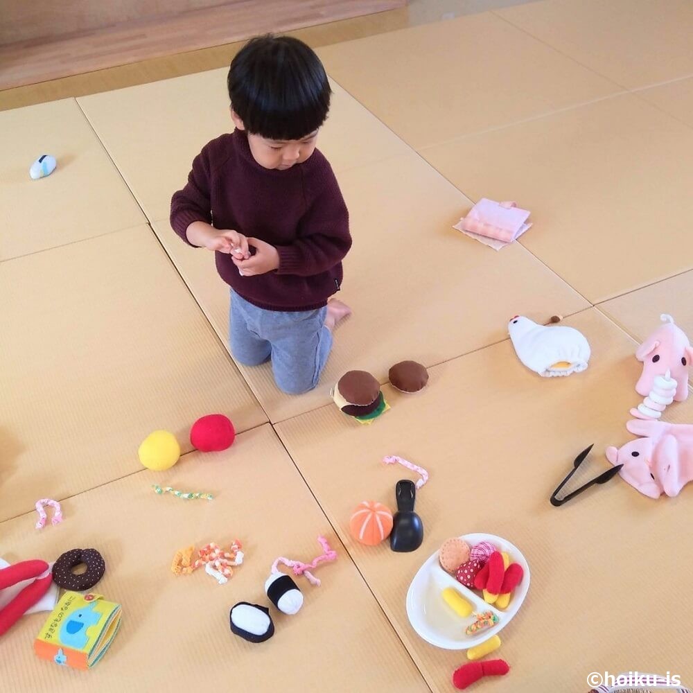 布おもちゃを床に広げる男の子