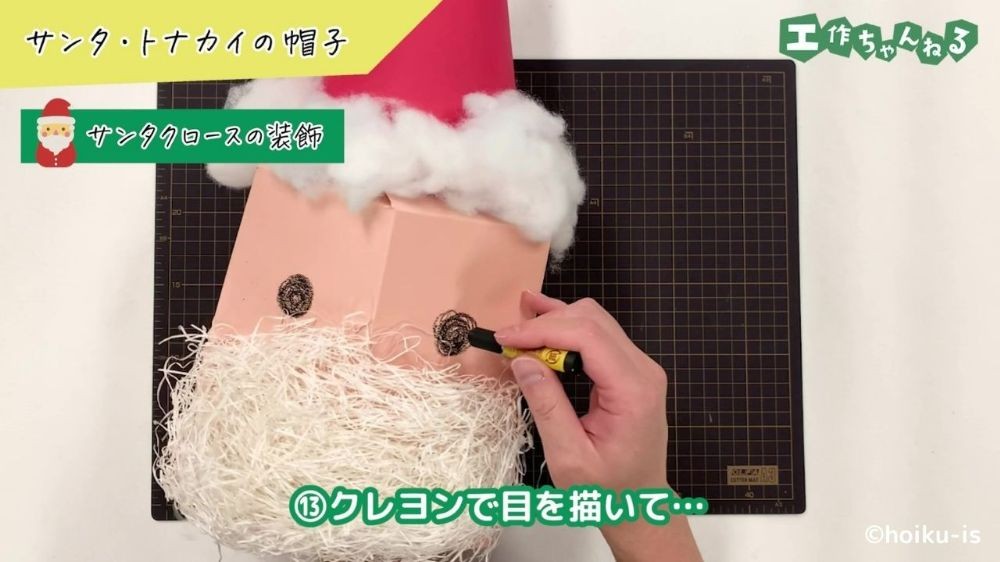 クレヨンでサンタの目を描いている手元
