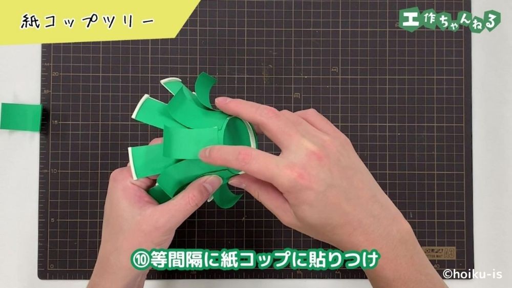 紙コップに切った画用紙を貼り付けている手元
