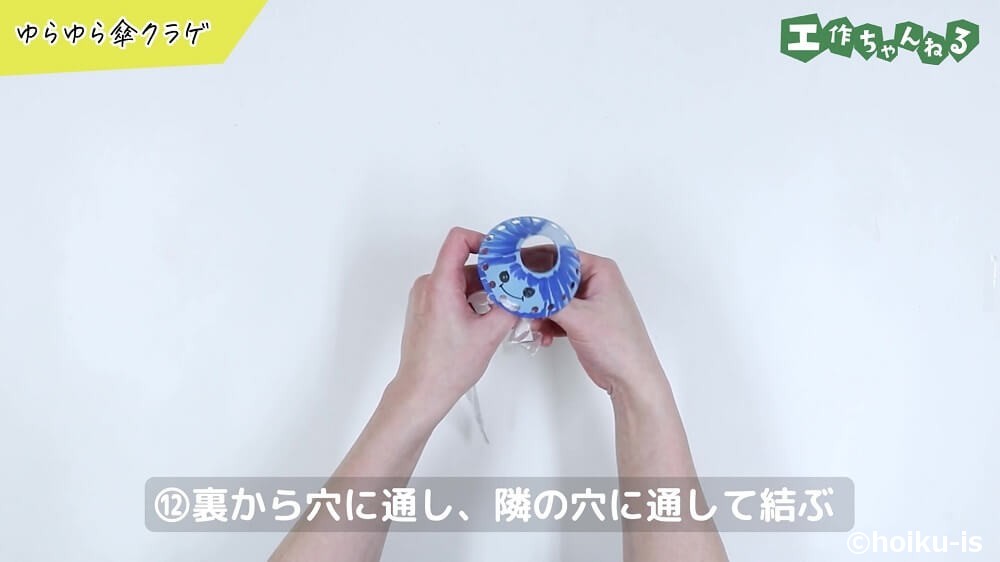 裏から穴に通し、隣の穴に通して結ぶ