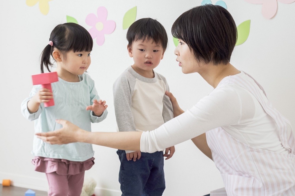 園児に注意をする保育士