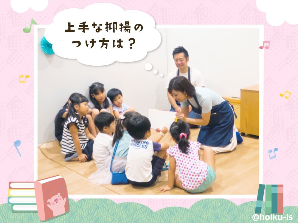 子どもたちに絵本を見せる保育士