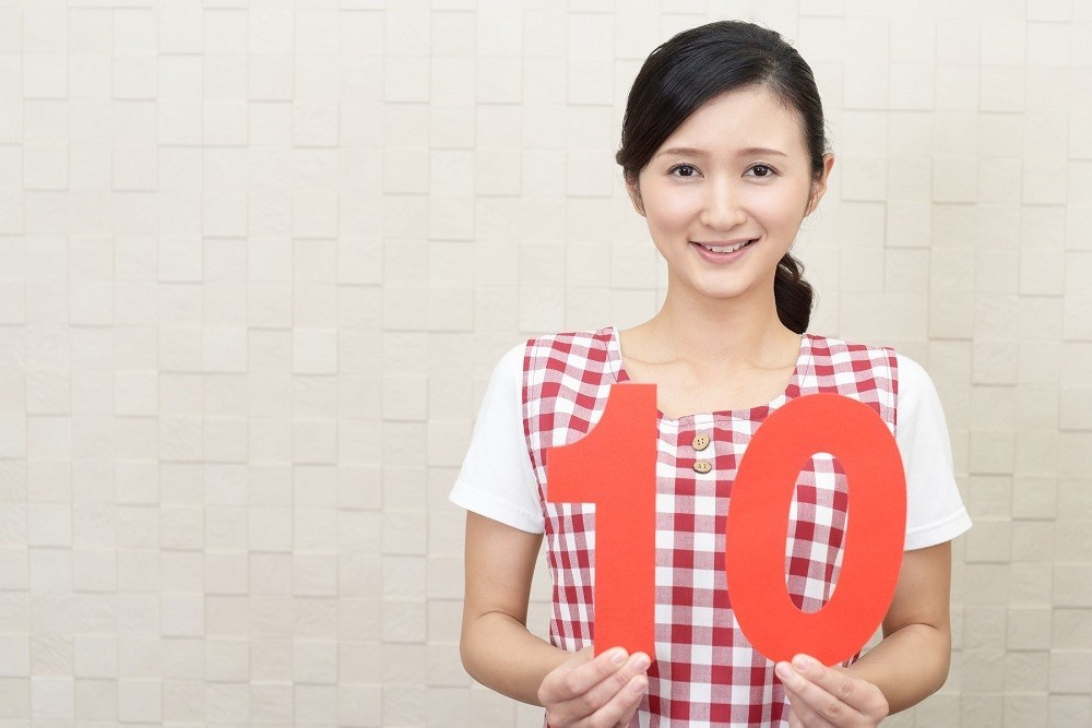 数字の10のパネルを掲げている保育士