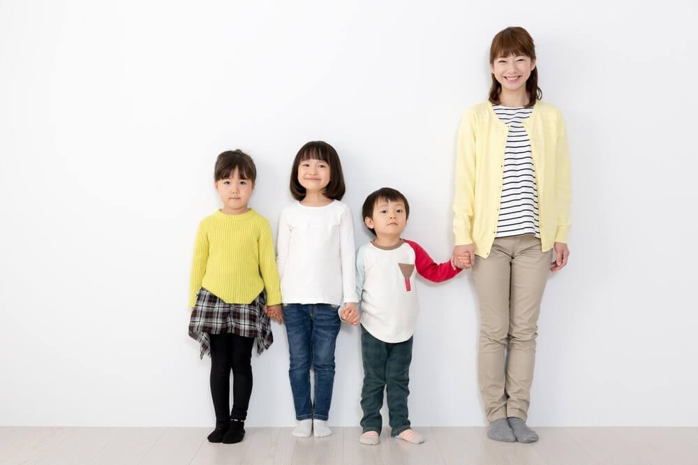 手をつないで並んだ保育士と子どもたち