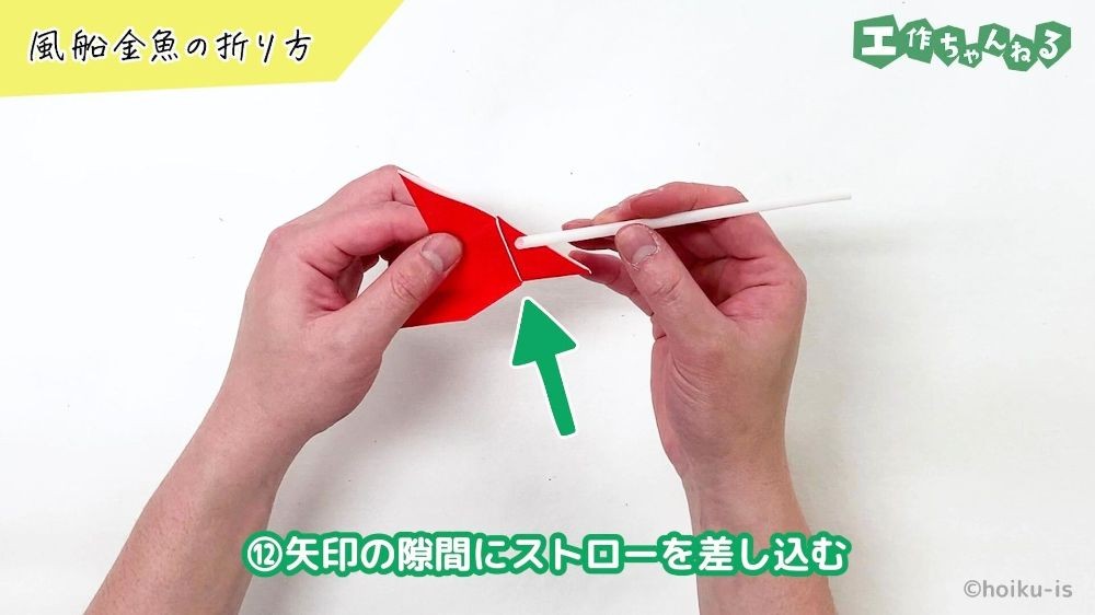 折り紙の隙間にストローを差し込んでいる手元