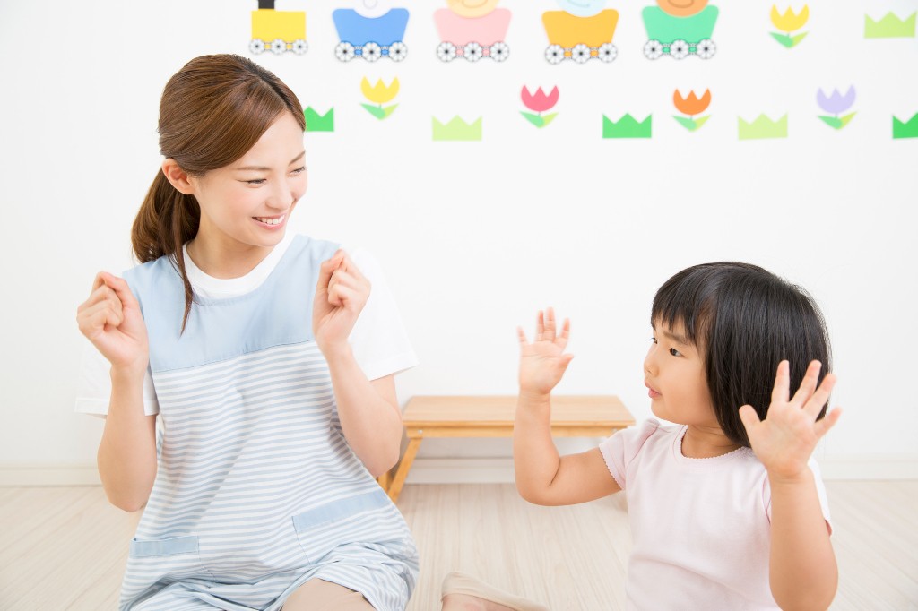 手遊びをする保育士と園児