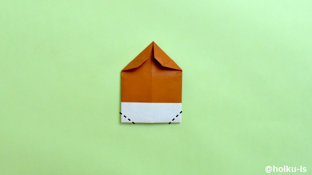 下の左右の角を、点線で谷折りにします