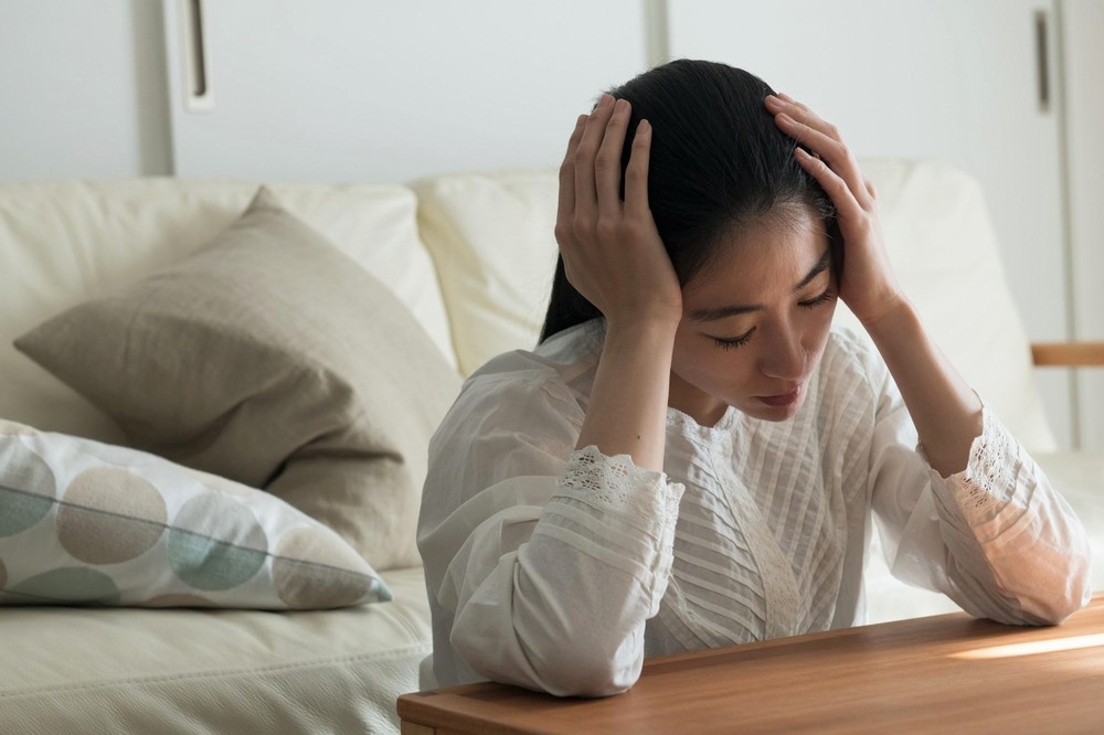 頭を抱えて悩む女性