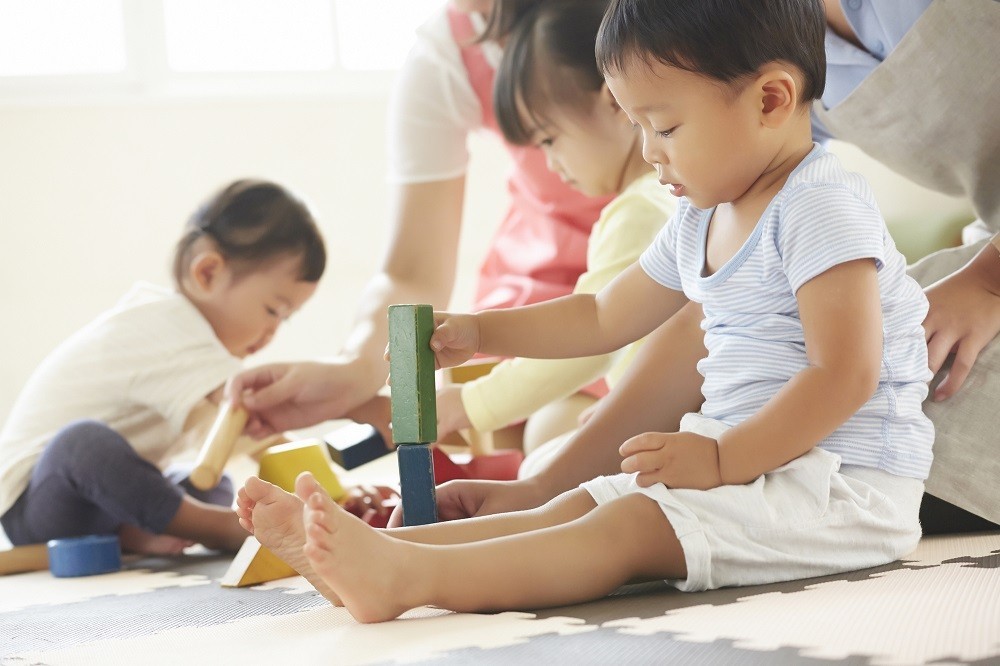 積み木で遊ぶ子どもたちと保育士