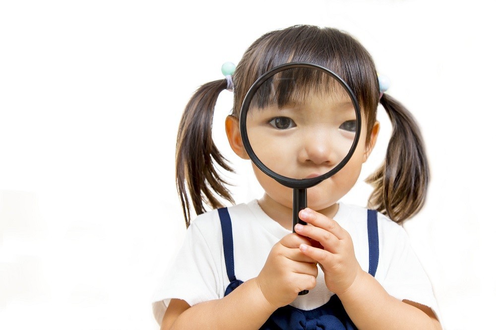 虫眼鏡を覗いている女の子