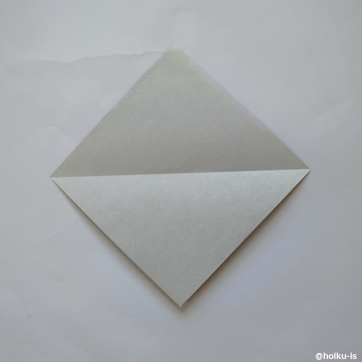対角線の折筋がつくようにもう一度三角形を折ります
