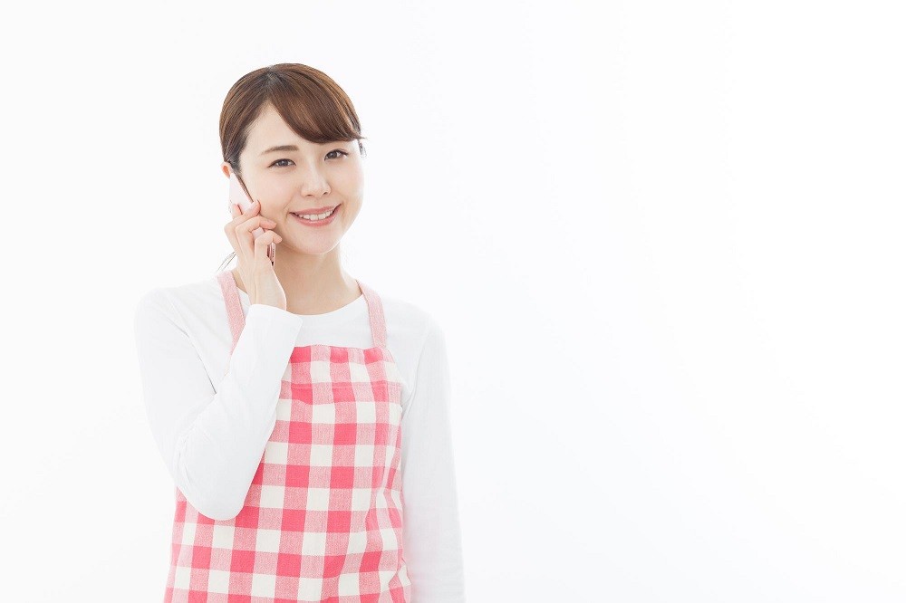 携帯で電話をする保育士