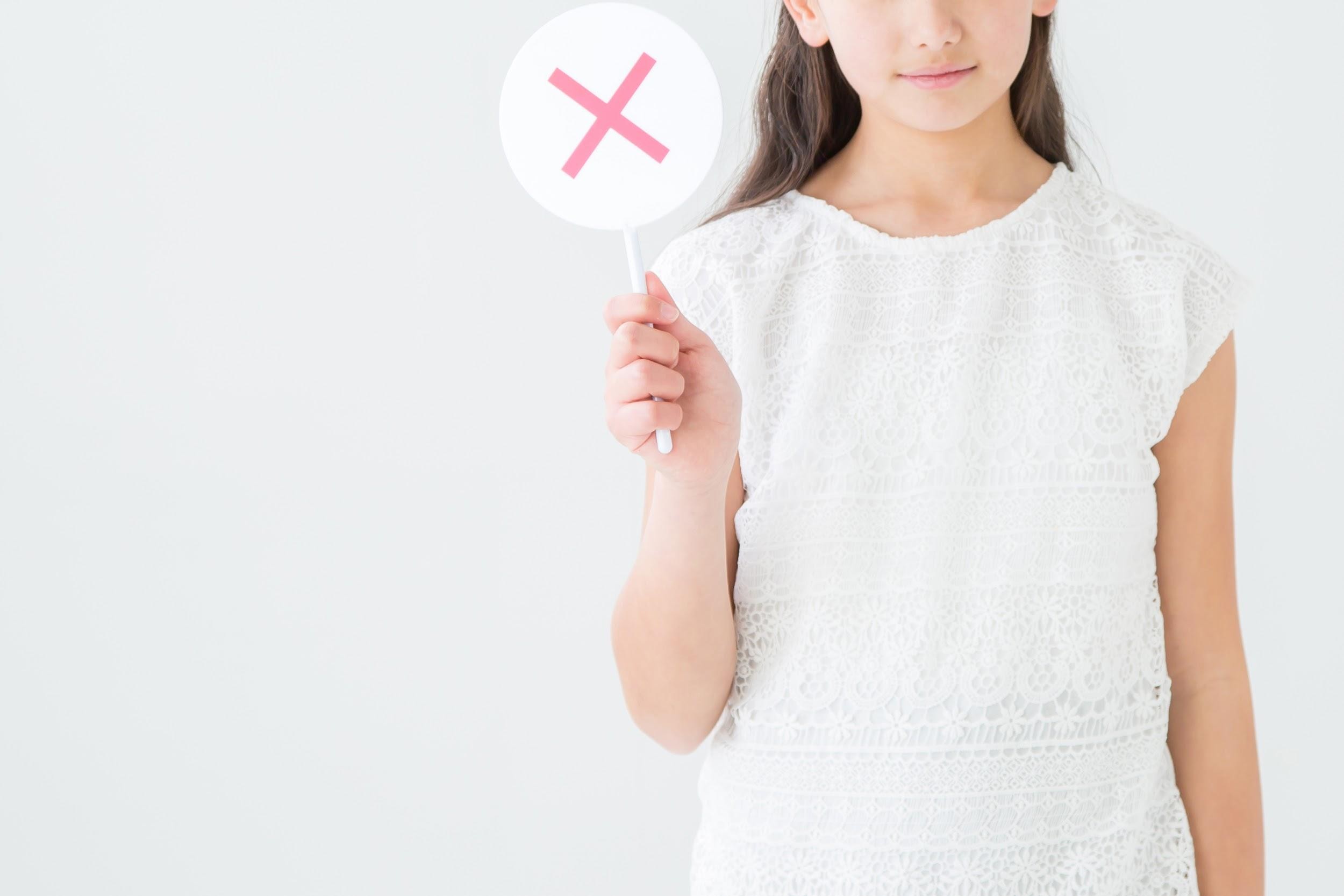 ×マークを持っている女の子
