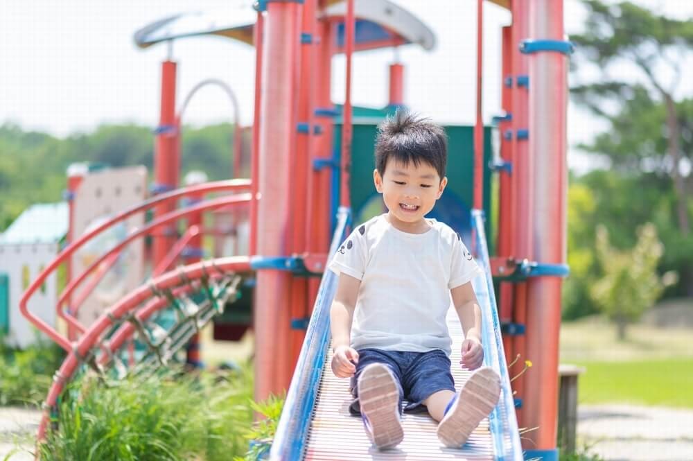 すべりだいを滑る子ども