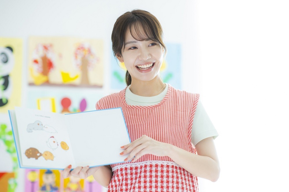 絵本の読み聞かせをする保育士