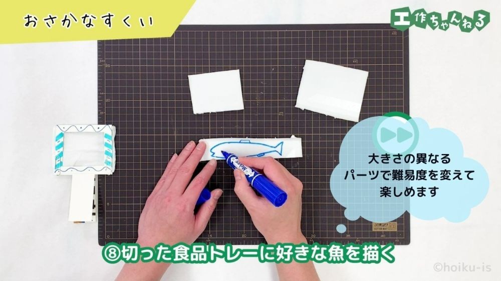 食品トレーに魚のイラストを描いている手元