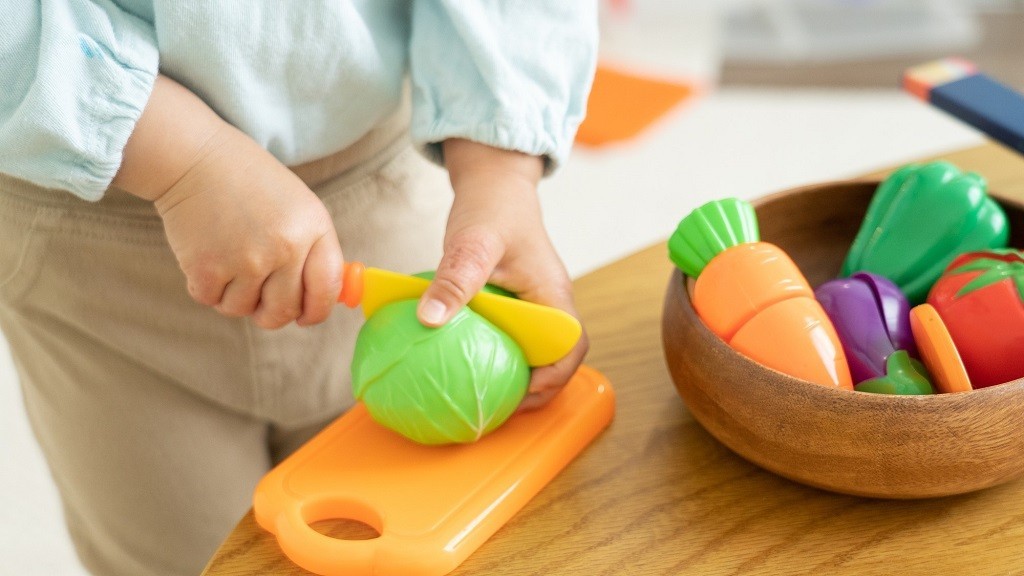 料理のままごとセットでごっこ遊びをする子ども