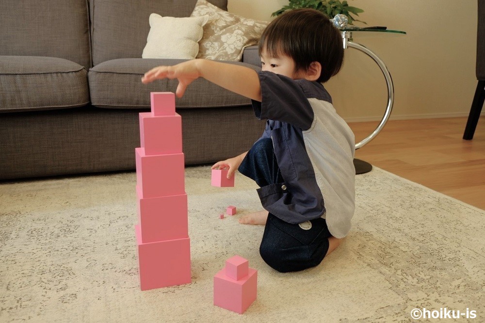 ピンクタワーを積み上げて遊ぶ男の子