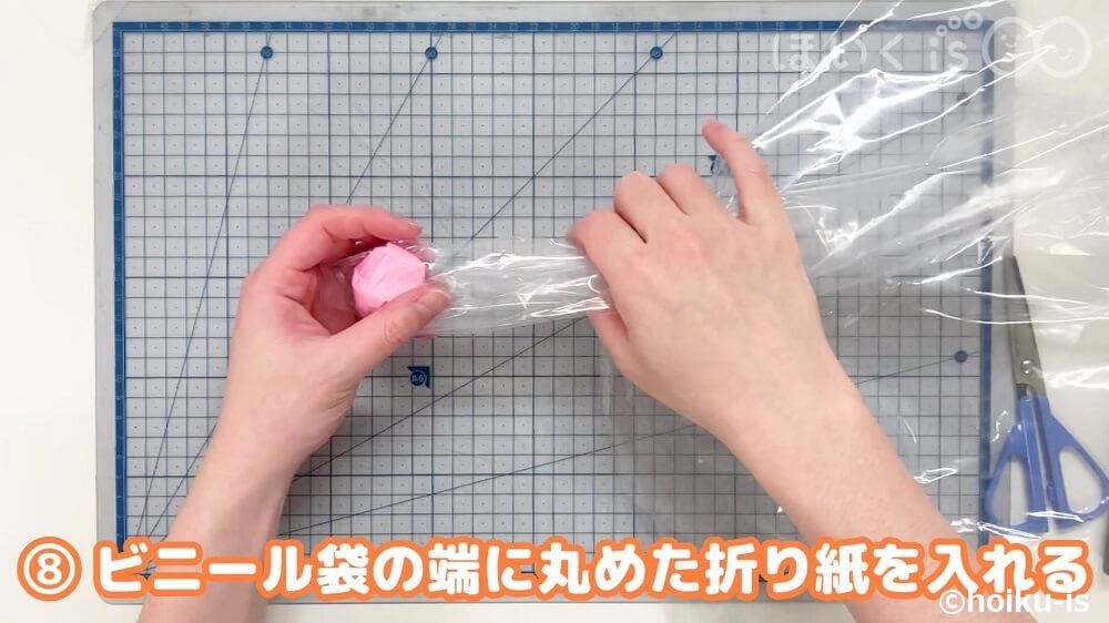 ビニール袋の端に丸めた折り紙を入れる