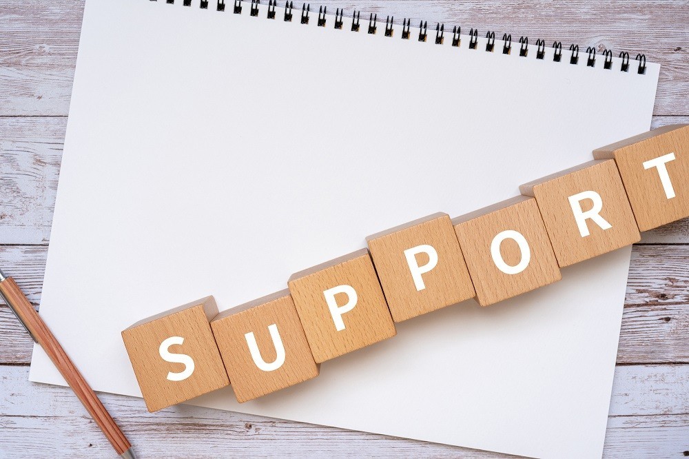 「SUPPORT」と書かれた積み木とスケッチブック