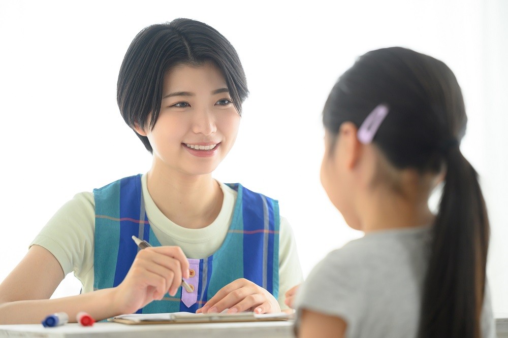 笑顔で子どもと会話をしている保育士