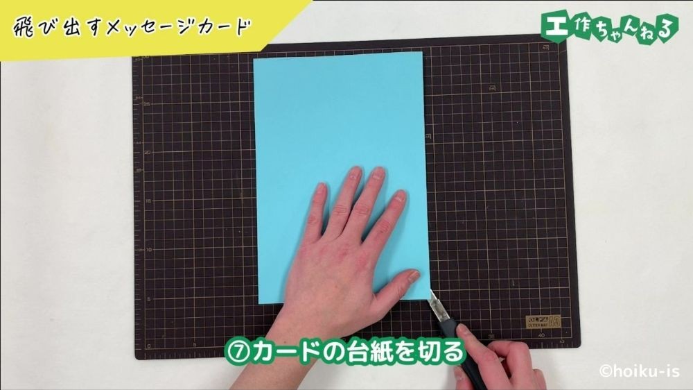 カッターで画用紙を切っている手元