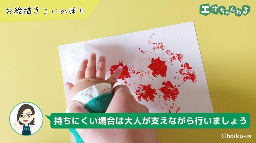 スタンプをする子どもの手と支える大人の手