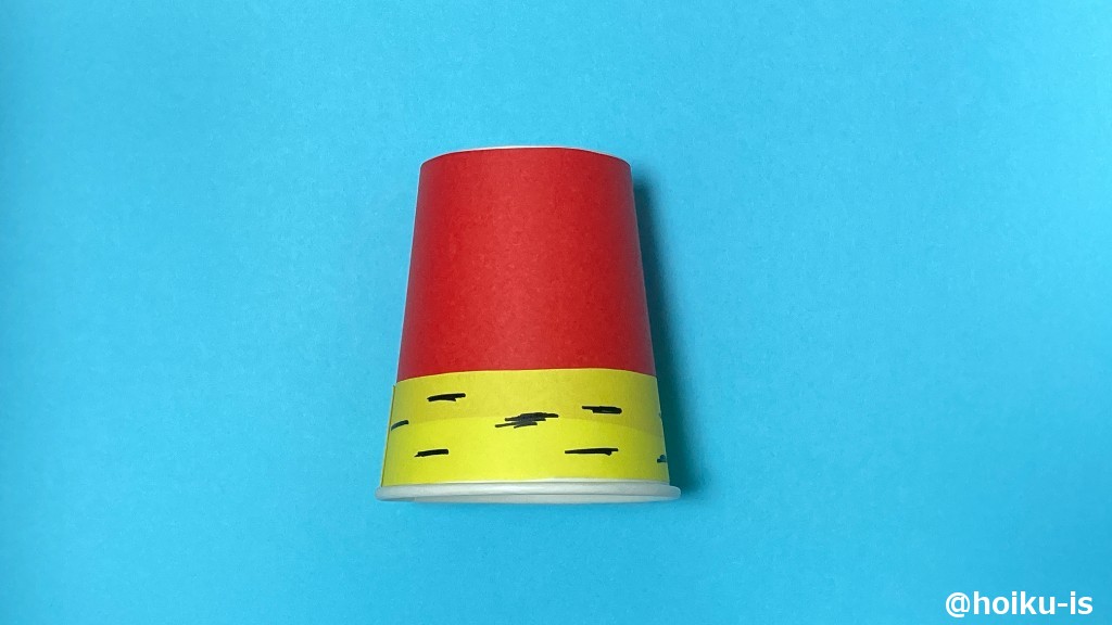 紙コップの下1/3くらいに(赤い折り紙に少し被るように)黄色の折り紙を貼る