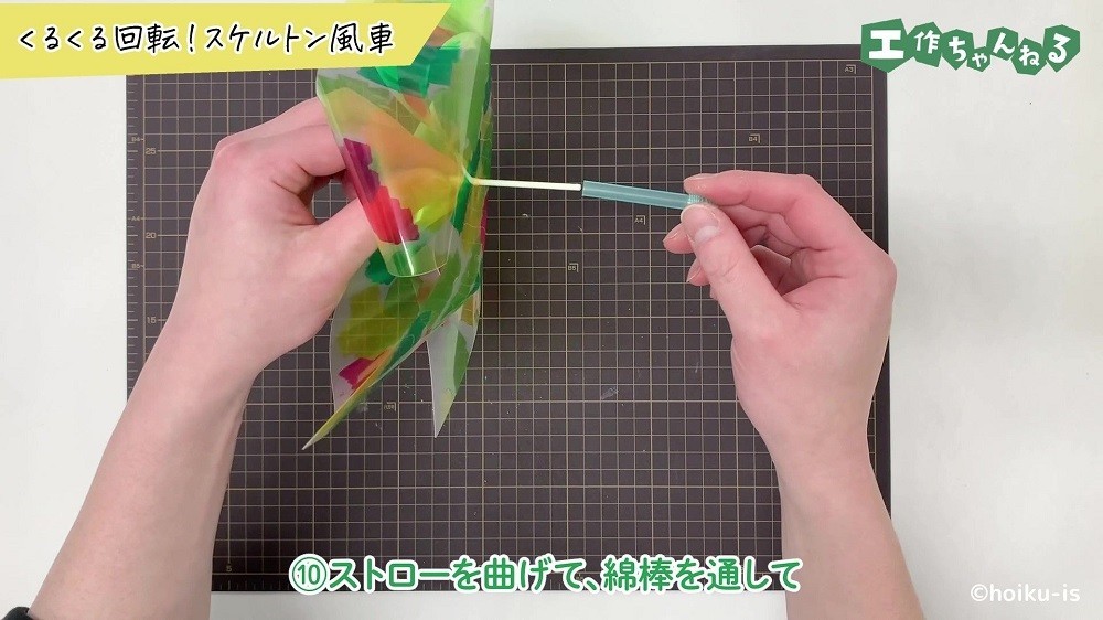 透明なストローに綿棒を通している手元