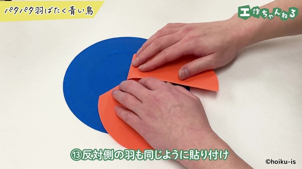 紙皿に貼られた色画用紙を押さえている手元