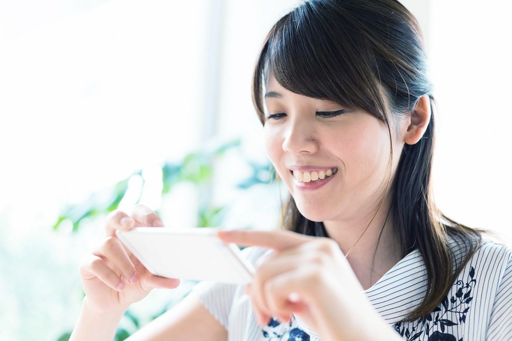 スマートフォンで撮影をしている保育士