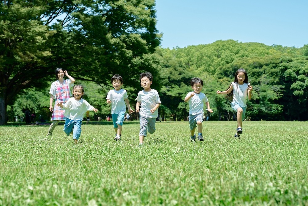 原っぱを走る子どもたち