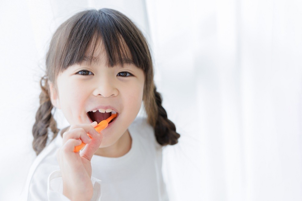 笑顔で歯磨きをしている子ども